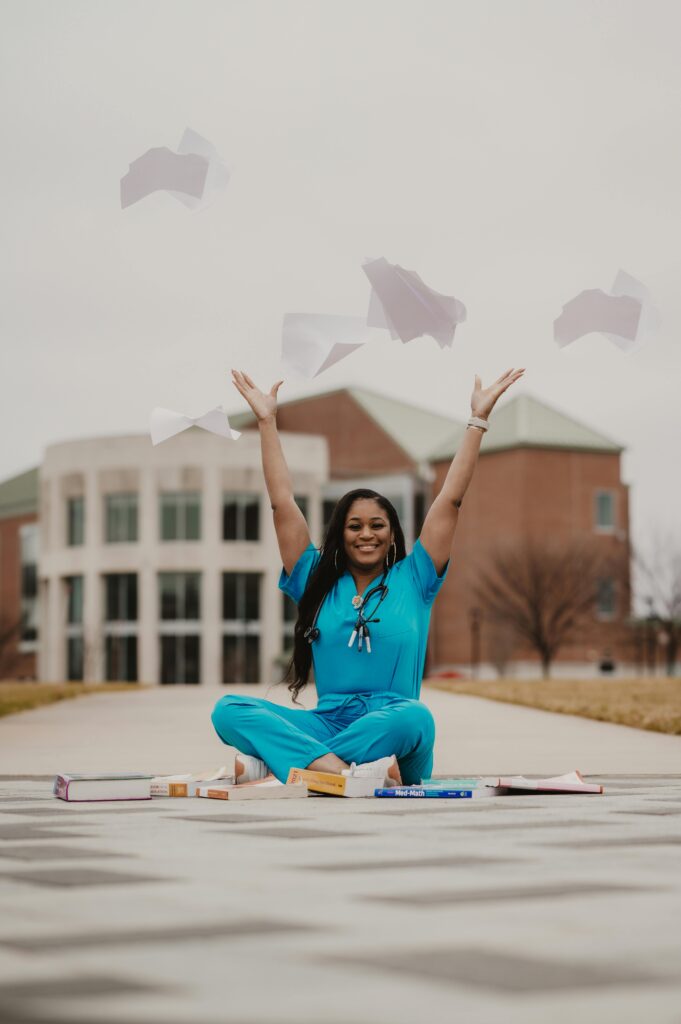 pexels-photo-19547594-19547594 Happy medical student in blue scrubs celebrates graduation by tossing papers outdoors.